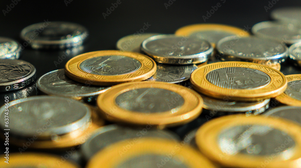 Moedas brasileiras de um real e de cinquenta centavos em um fundo neutro Moedas brasileiras de um real e de cinquenta centavos em um fundo neutro