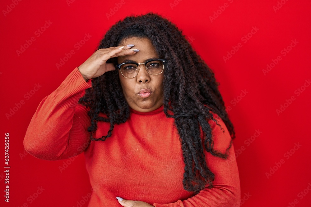 Plus size hispanic woman standing over red background worried and stressed about a problem with hand on forehead, nervous and anxious for crisis Plus size hispanic woman standing over red background worried and stressed about a problem with hand on forehead, nervous and anxious for crisis