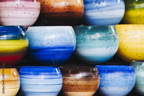 Bols en céramique colorée empilée sur un étal de marché de potiers photo