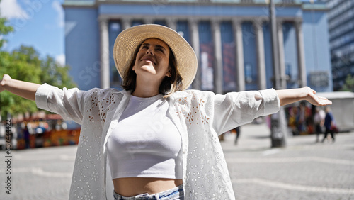 Canvas Print Beautiful young hispanic woman smiling confident wearing summer hat standing wit