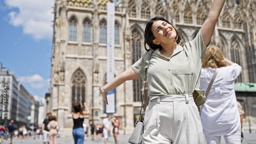 Obraz premium Young beautiful hispanic woman with open arms at St. Stephen's Cathedral