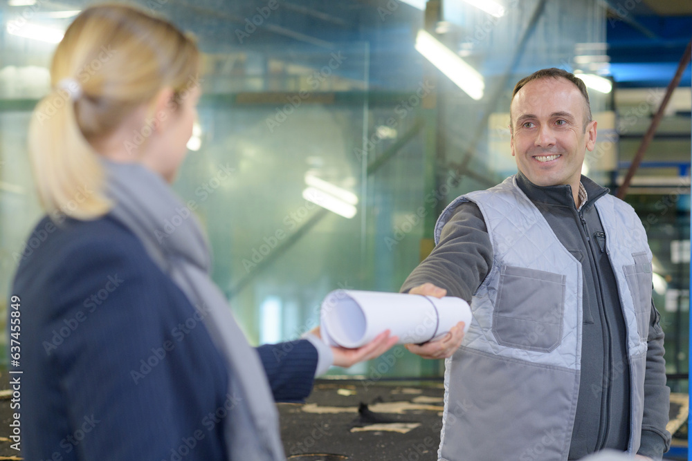 happy industrial engineer giving blueprint to worker happy industrial engineer giving blueprint to worker