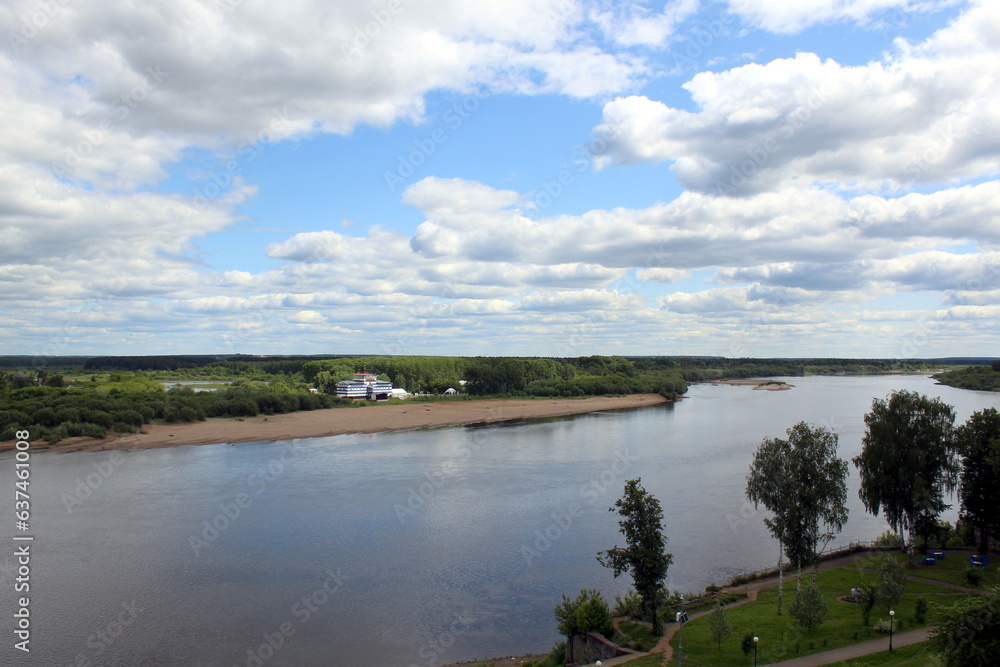 Beautiful view of a flowing river in summer with trees and fields.	