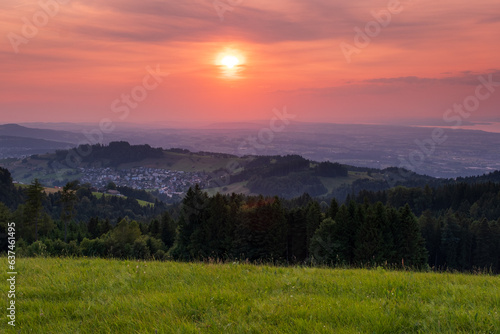Sonnenuntergang mit Weitblick über grüne Hügel