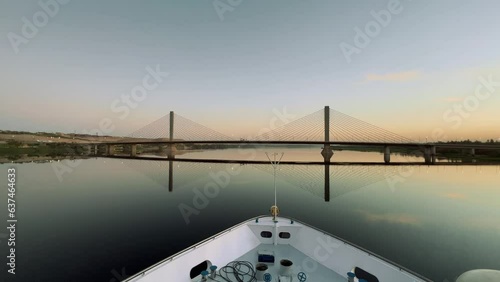 Nile Sunrise Serenity: Cruise Ship Under Bridge