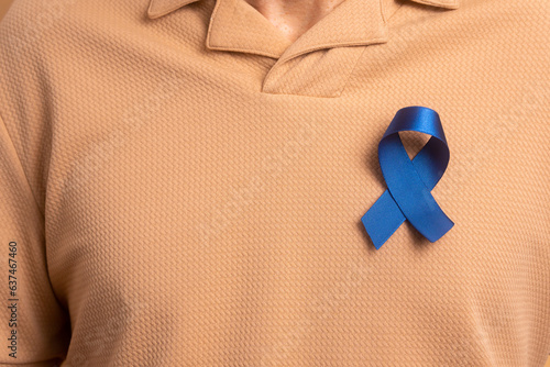 anonymous mature man showing blue ribbon in all beige colors. prostate cancer, awareness concept.