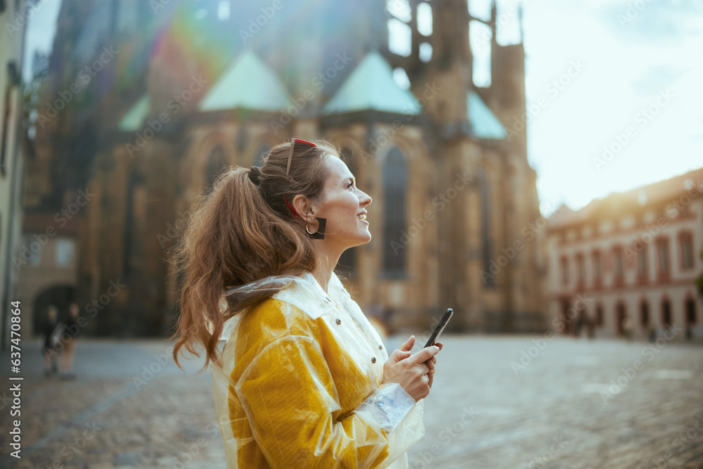 woman in Prague enjoying promenade and using smartphone