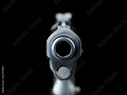 The muzzle part of the pistol scene Pointed Directly at Viewer on a black background represents a concept related to the concept of abstract weapons.No Discernible Person. photo