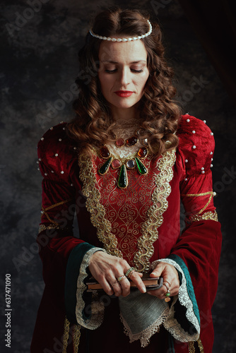 medieval queen in red dress with book and handkerchief