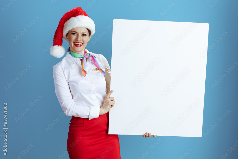smiling female flight attendant on blue showing blank board smiling female flight attendant on blue showing blank board