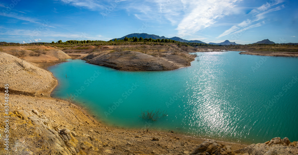 Panoramic view of the Cenajo reservoir, in Albacete, Spain, with blue-green waters and midday light