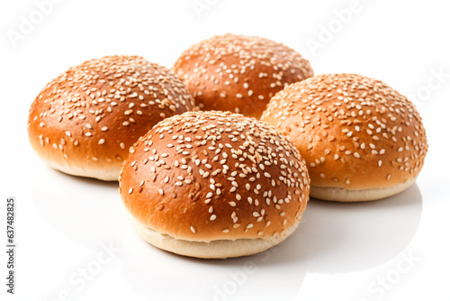 a group of four sesame buns on a white surface
