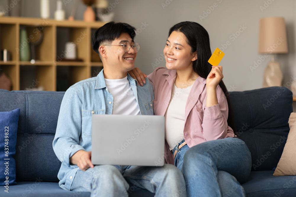 Korean Couple Shopping Online Using Laptop And Credit Card Indoor Korean Couple Shopping Online Using Laptop And Credit Card Indoor