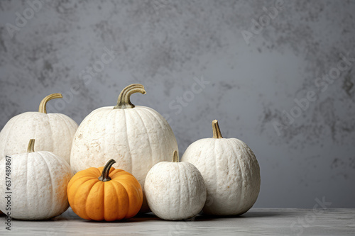 Белые и оранжевые тыквы на фоне серой стены, минимальная ретушь, мрамор