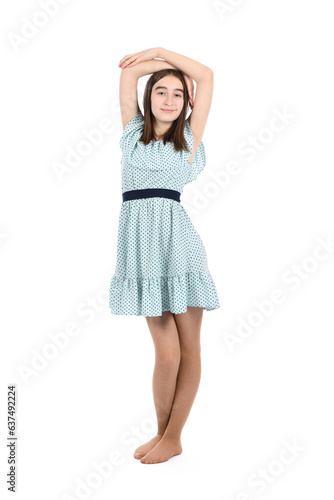 Young beautiful girl in a dress with polka dots on a white background.