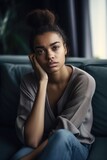shot of a young woman looking upset while sitting on her sofa at home