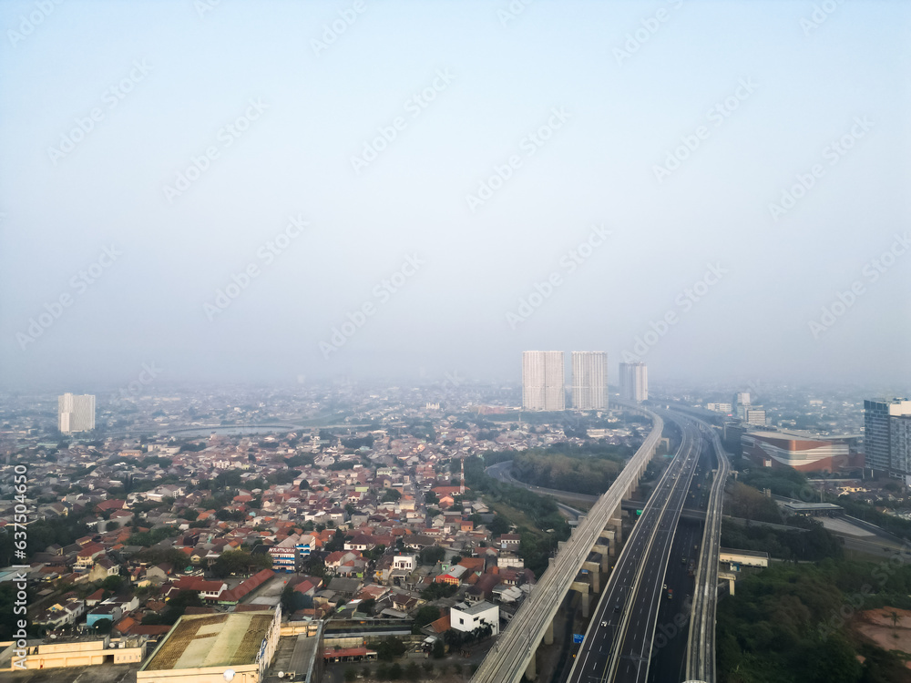 Bekasi City with long highway, tall buildings and smog due to air pollution. Poor air quality in the Jabodetabek area. Concept for climate change, global warming.
