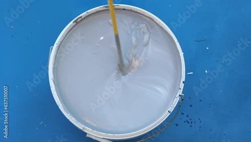 Mixing and stirring paint for have new colour.