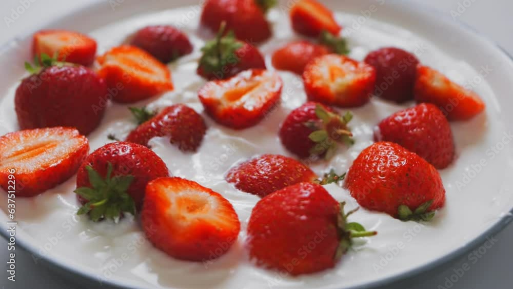 Juicy ripe red strawberries whole and halves in heavy cream rotate in a circle. Slowmotion Juicy ripe red strawberries whole and halves in heavy cream rotate in a circle. Slowmotion