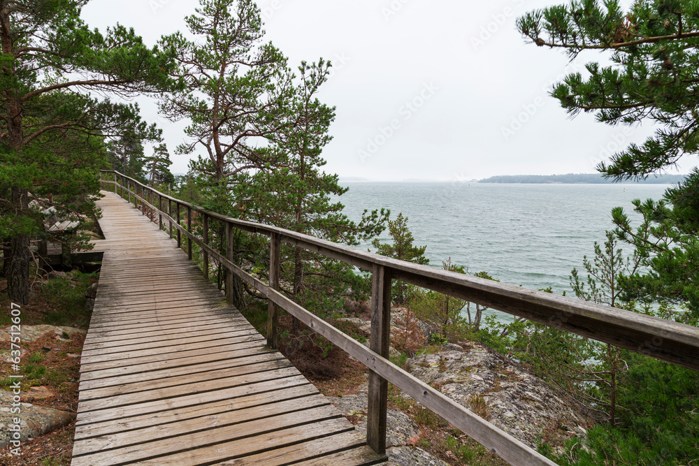 Elevated seaside wooden walkway on a cliff by the Baltic sea in Mariehamn, Åland Islands, Finland, on a cloudy day.
