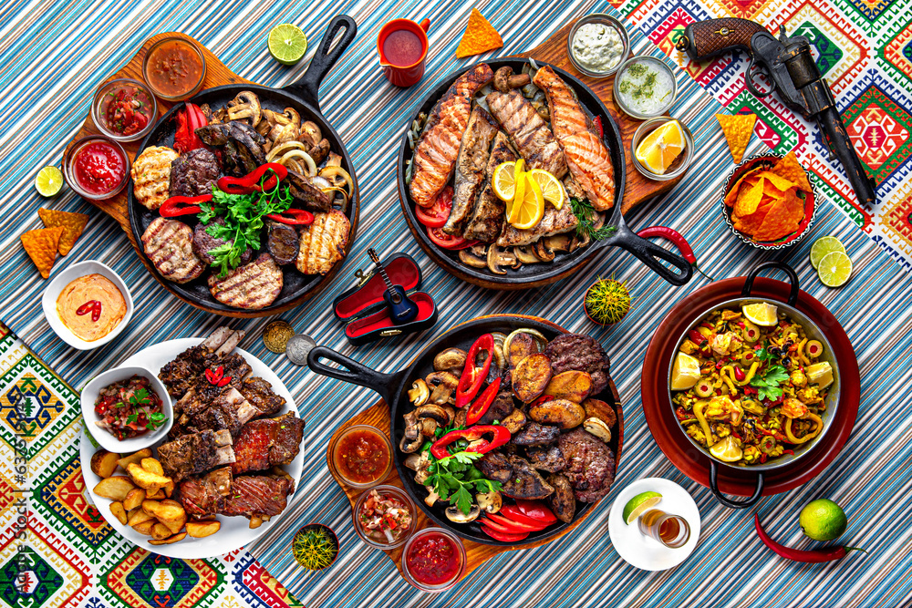 Traditional mexican food. The assortment of mega grills in hot pans of fish, beef, chicken, lamb. Colorful Food Table Celebration Delicious Party Meal Concept. 