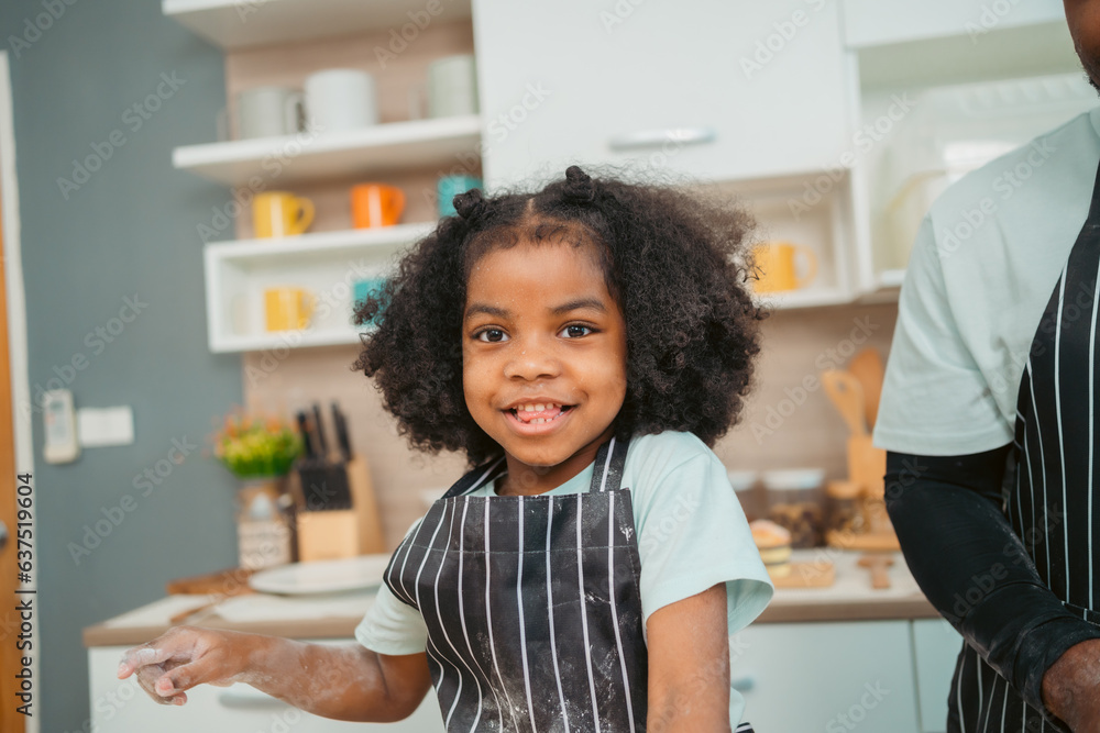 Kind African american parents teaching their adorable daughter how to cook healthy food, free space of kitchen, Happy black people family preparing healthy food in kitchen together Kind African american parents teaching their adorable daughter how to cook healthy food, free space of kitchen, Happy black people family preparing healthy food in kitchen together