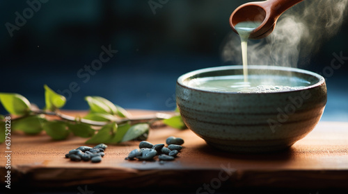 Hot blue matcha pouring into cup. Tea leaves on wooden background. Banner. Generative Ai content
