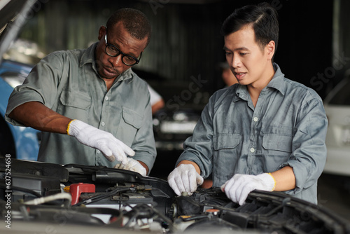 Car mechanics discussing the best way to repair engine