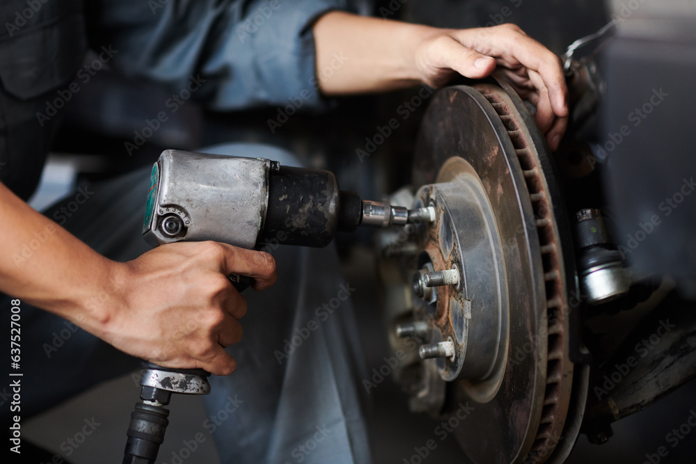 Hands of mechanic changing car tyre for client Hands of mechanic changing car tyre for client