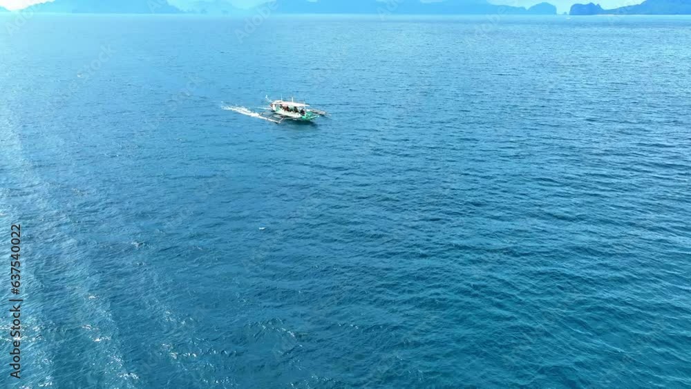 Aerial Panning Shot Of People In Boat On Blue Sea Against Mountains During Sunny Day - El Nido, Philippines Aerial Panning Shot Of People In Boat On Blue Sea Against Mountains During Sunny Day - El Nido, Philippines
