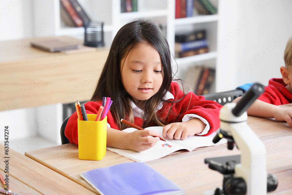 Little school girl in classroom during lesson Little school girl in classroom during lesson