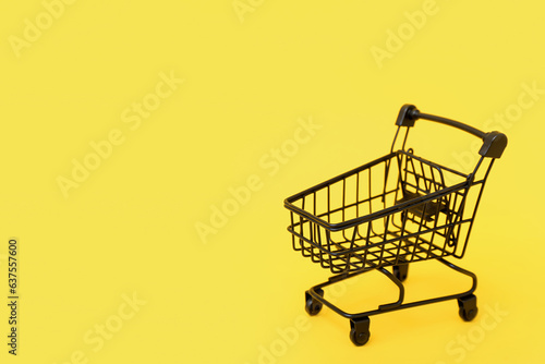 Small shopping cart on yellow background