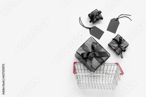 Shopping basket with gift boxes on white background. Black Friday concept