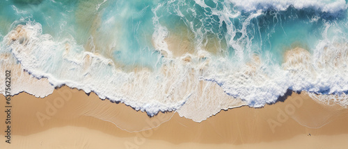 Przypływ spienionych fal morskich na piaszczystej złotej plaży w widoku z lotu ptaka photo