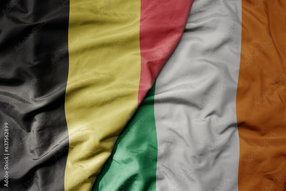 big waving national colorful flag of belgium and national flag of ireland .