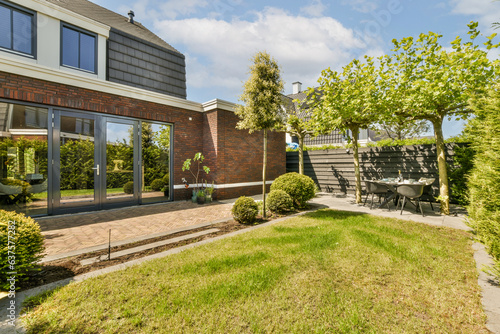 an outside area with grass, bushes, and trees in front of a house that has been built for sale © Casa imágenes