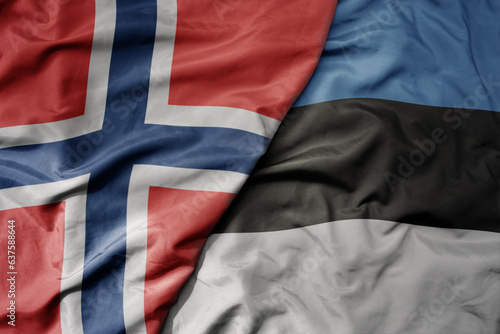 big waving national colorful flag of norway and national flag of estonia .