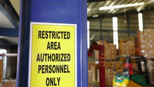 Yellow Restricted Area Sign In Warehouse
