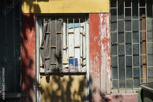 Vergitterte Fenster und Türen mit Sichtschutz in Beige und Braun des heruntergekommenen Altbau im Sommer bei Sonnenschein in den Gassen der Altstadt von Ayvalik in der Provinz Balikesir in der Türkei photo