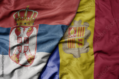big waving national colorful flag of serbia and national flag of andorra .