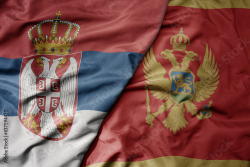 big waving national colorful flag of serbia and national flag of montenegro .