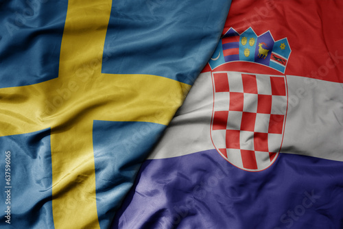 big waving national colorful flag of sweden and national flag of croatia .