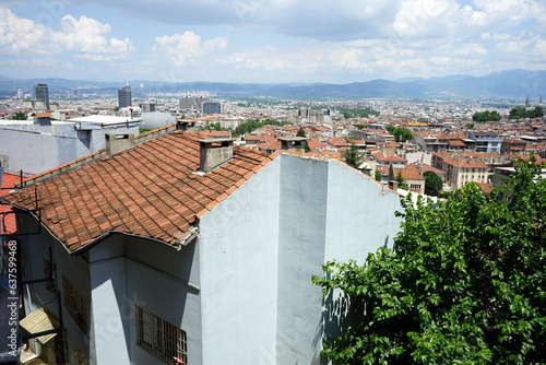 Panoramablick über alte rote Ziegeldächer auf die Stadt und das Uludag Gebirge aus einem Café und Restaurant an der Grünen Moschee im Sommer bei Sonnenschein in der Altstadt von Bursa in der Türkei