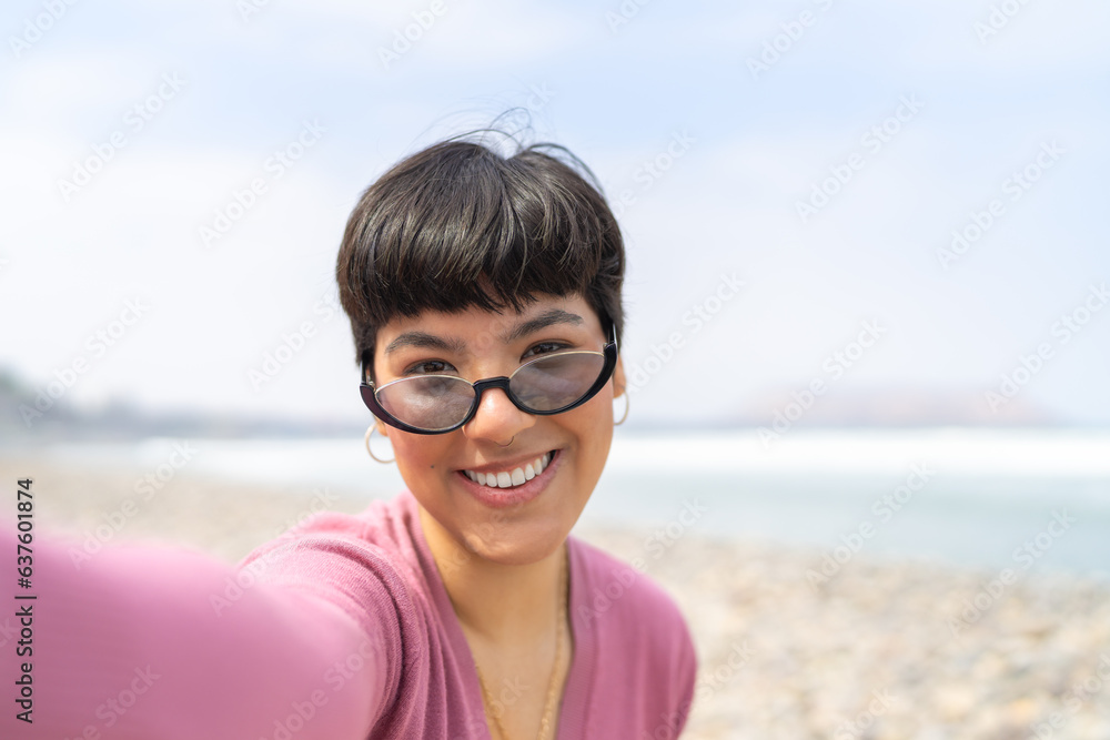 Frontal view of a woman taking selfie on the beach