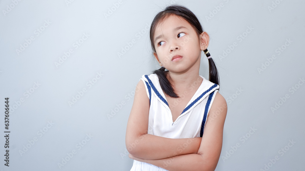 Portrait little girl with folded arms with dissatisfied grimacing face glanced sideways. Portrait little girl with folded arms with dissatisfied grimacing face glanced sideways.