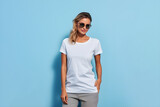 A woman wearing white tshirt mockup, at blue background. Design tshirt mock-up, print presentation mock-up. AI generated.
