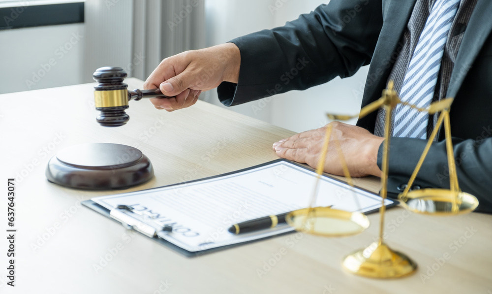 Lawyer hand holding gavel hammer hit and providing legal consult business dispute service to the man at the office with justice scale Lawyer hand holding gavel hammer hit and providing legal consult business dispute service to the man at the office with justice scale