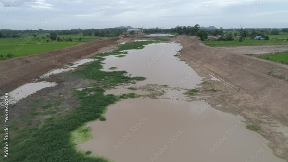 Construction dredges up for a canal and dam, to prevent a flood in the rainy season. Date on 14 May 2021 at Uthai Thani province, Thailand. Construction dredges up for a canal and dam, to prevent a flood in the rainy season. Date on 14 May 2021 at Uthai Thani province, Thailand.