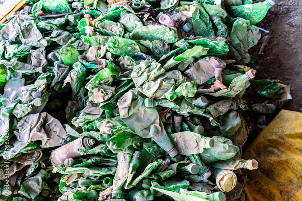 Lots of green plastic bottles and plastic wasted products being smashed on ground for recycle purpose Lots of green plastic bottles and plastic wasted products being smashed on ground for recycle purpose