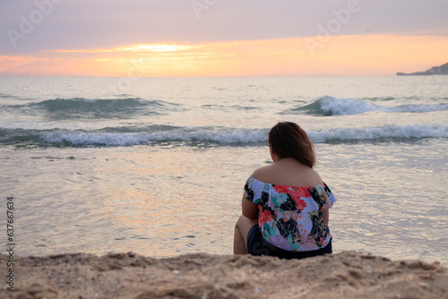 pensive latin woman in front of the sea at sunset